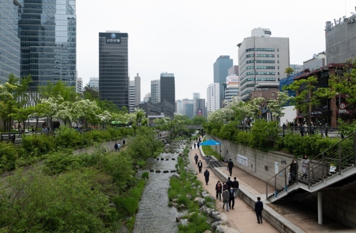 Menschen mit Schutzmasken spazieren während der Corona-Pandemie entlang des Cheonggyecheon-Bachs in Seoul. Foto: EPA/Jeon Heon-kyun