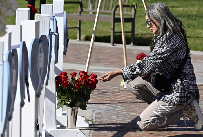 Lisa Lozano kniet vor Rosen an einer Gedenkstätte vor dem Rathaus, nach tödlichen Schüssen am 21. Januar, inmitten von Neujahrsfeierlichkeiten in einer überwiegend asiatisch-amerikanisch... Foto: Keith Birmingham/The Orange County Register/ap/dpa
