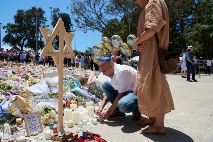 Menschen legen Blumen an einem Gedenkort am Bondi Beach nieder und trauern um die Opfer des tödlichen Angriffs in Sydney. Foto: EPA/Flavio Brancaleone