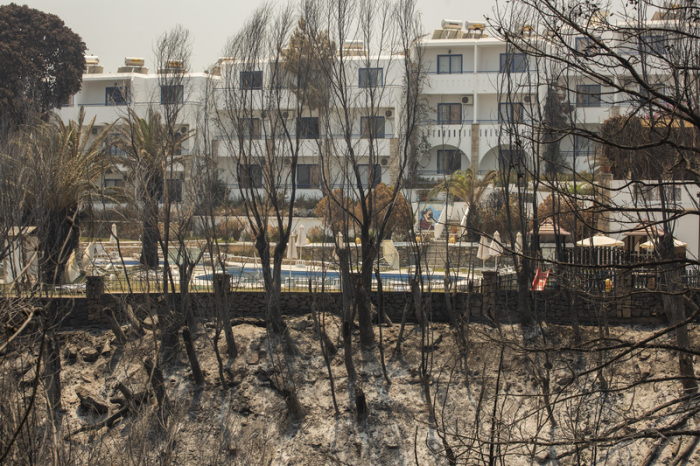 Verbrannte Bäume sind Neben einem Hotel in der Nähe des Dorfes Gennadi zu sehen. Auf Rhodos und in anderen Teilen Griechenlands toben Waldbrände. Foto: Socrates Baltagiannis/dpa