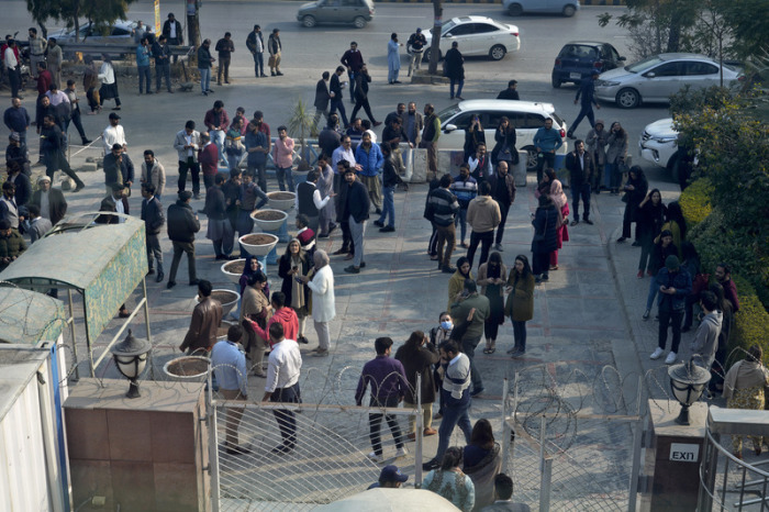 Menschen stehen vor einem Bürogebäude, nachdem ein Erdbeben zu spüren war. Ein Erdbeben der Stärke 6,4 erschütterte weite Teile Pakistans und einen Teil des benachbarten Afghanistans. Foto: Anjum Naveed/Ap/dpa