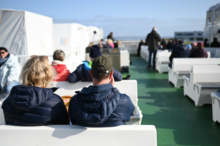 Viele Fahrgäste sitzen an Deck der Fähre nach Norderney. Heute soll es sonnig oder nur locker bewölkt sein. Foto: Lars Penning (Klemmer)/dpa