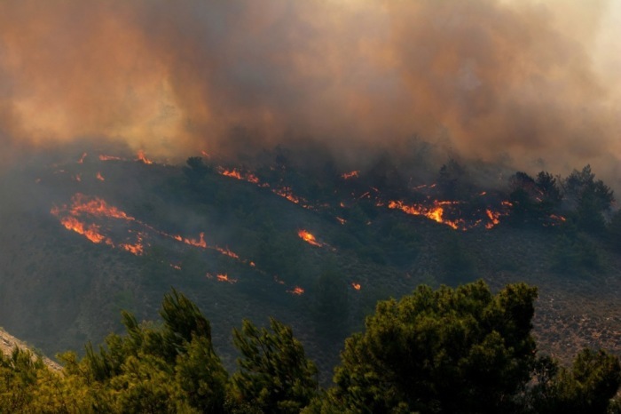 Ein Feuer verbrennt Bäume und niedrige Vegetation in der Gegend von Malona auf Rhodos. Foto: epa/Lefteris Damianidis