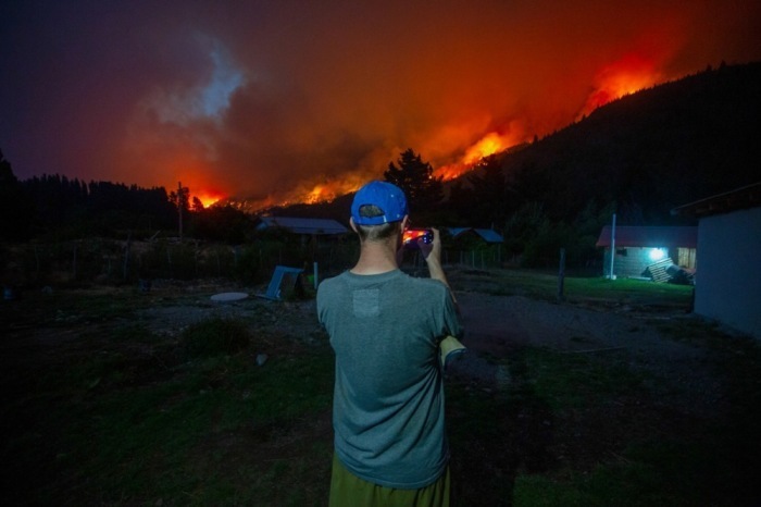 Ein Mann fotografiert einen Waldbrand in El Hoyo, während sich Feuer in Patagonien ausbreiten und tausend Hektar zerstören. Foto: epa/Matias Garay