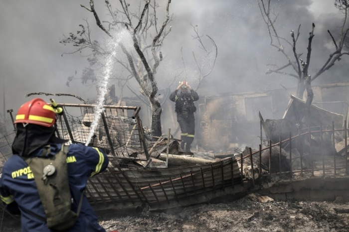 Feuerwehrleute versuchen, einen Brand in einem Wohngebiet am Fuße des Parnitha-Bergs in den Außenbezirken von Athen zu löschen. Foto: epa/Kostas Tsironis