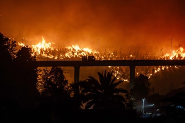 Ein Waldbrand erfasst Wohnhäuser in Penco. In mehreren Feuern im Süden Chile kamen mindestens 16 Menschen ums Leben. Foto: epa/Pablo Hidalgo
