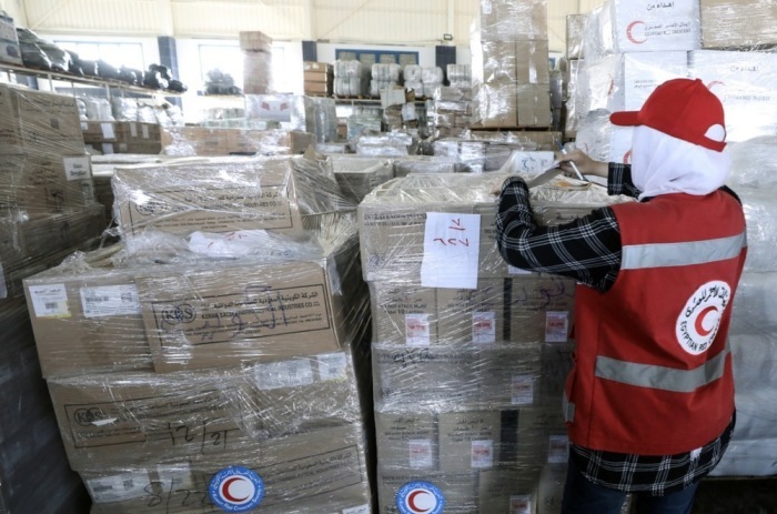 Ein Mitarbeiter des Ägyptischen Roten Halbmonds nimmt in einem Lagerhaus in Arish Pakete mit humanitärer Hilfe für die Palästinenser im Gazastreifen entgegen. Foto: epa/Khaled Elfiqi