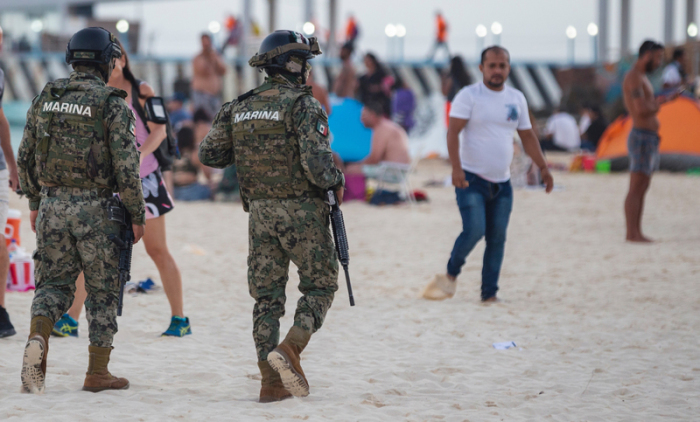 Schwer bewaffnete Soldaten der mexikanischen Marine patrouillieren auf einem Strand. Foto: Natalia Pescador/dpa