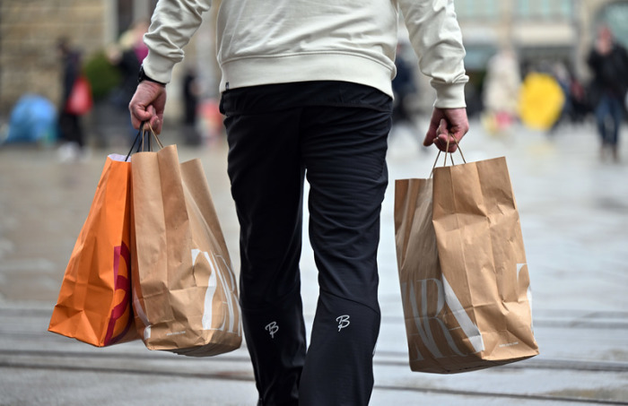 Ein Mann trägt Einkaufstüten durch die Innenstadt. Das Statistische Bundesamt veröffentlicht am 29.04.2022 Zahlen zum Bruttoinlandsprodukt (Schnellmeldung) im 1. Quartal 2022. Foto: Martin Schutt/dpa