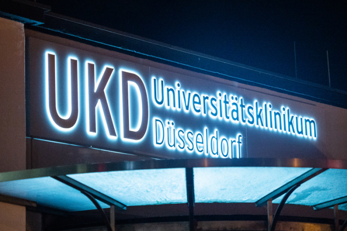 Das Logo des Universitätsklinikums Düsseldorf UKD leuchtet an einem Eingang des Krankenhauses. Foto: Christophe Gateau/dpa