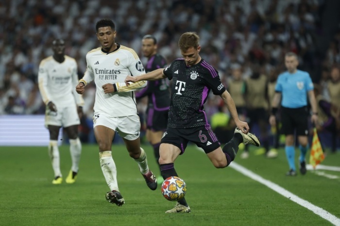 Joshua Kimmich (R) von Bayern München in Aktion gegen Jude Bellingham von Real Madrid. Foto: epa/Juanjo Martin