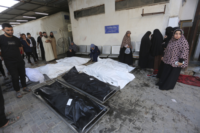 Palästinenser stehen vor einem Leichenschauhaus in Rafah um die Leichen von Menschen, die bei israelischen Bombardierungen im Gazastreifen getötet wurden. Foto: Hatem Ali