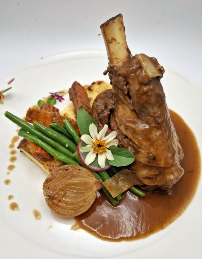 Die langsam geschmorte australische Lammhaxe wird mit gebratener Mais-Polenta, grünen Bohnen und kräftiger Jus serviert. Fotos: Vespresso Restaurant.