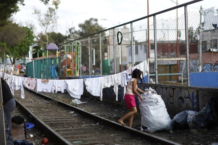 Eine Person geht an einer Wäscheleine in einem Migrantenlager in Mexiko-Stadt vorbei. Foto: EPA/Sashenka Gutierrez