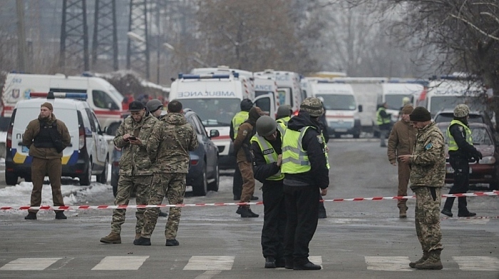 Polizeibeamte stehen in der Nähe einer Absperrung und von Krankenwagen in der Nähe eines von Granaten getroffenen Infrastrukturobjekts in Kiew (Kiev). Foto: EPA-EFE/Sergey Dolzhenko