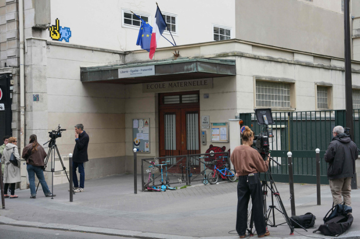 Journalisten filmen vor einem Kindergarten in Paris. Der Skandal um sexuelle Gewalt an Schulen und Kitas weitet sich aus. Foto: AFP/dpa/dimitar Dilkoff