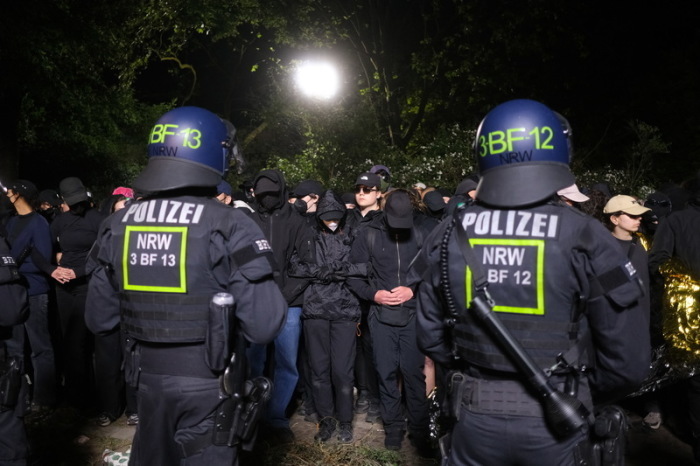 Demonstranten stehen während einer sogenannten polizeilichen Umschließung zusammen. Foto: Sebastian Willnow/dpa