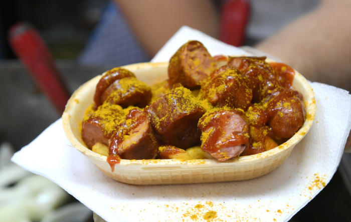 Eine Currywurst wird in einer essbaren Schale verkauft. Foto: Felix Hörhager/dpa