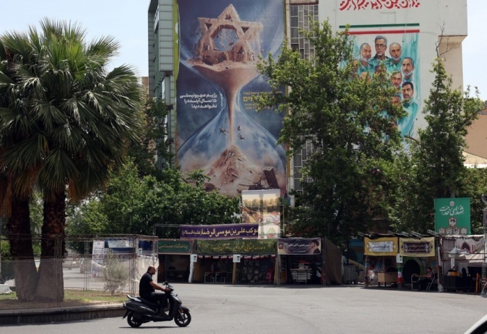 Autos fahren in Teheran an einem antiisraelischen Plakat auf dem Palästina-Platz vorbei Foto: EPA/Abedin Taherkenareh