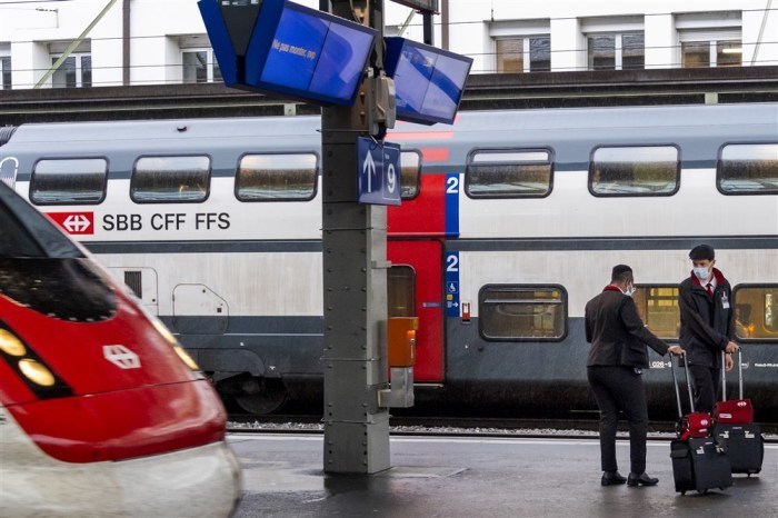 Zwei Mitarbeiter der Eisenbahngesellschaft CFF/SBB warten am Bahnhof CFF/SBB auf einen Zug. Foto: epa/Jean-christophe Bott