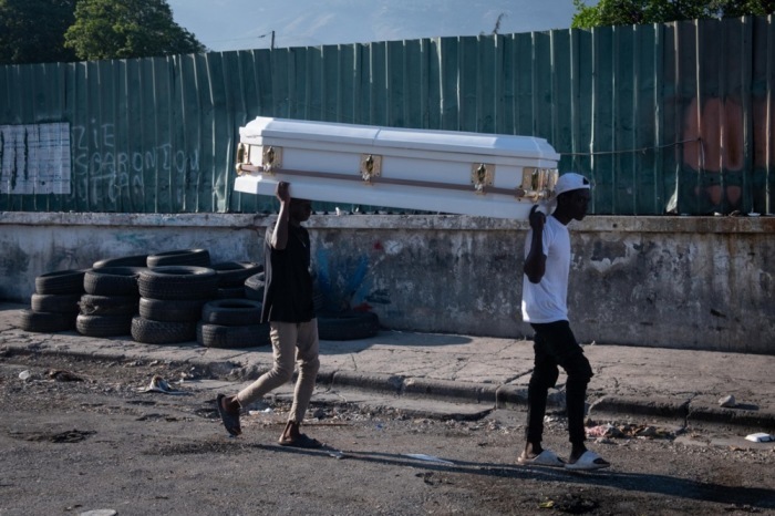 Zwei Männer tragen einen Sarg durch eine Straße in Port-au-Prince. Foto: epa/Johnson Sabin
