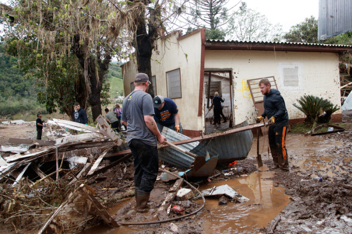Menschen entfernen Trümmer von Häusern nach schweren Unwettern im September 2023. Foto: Claudia Martini/Xinhua/dpa