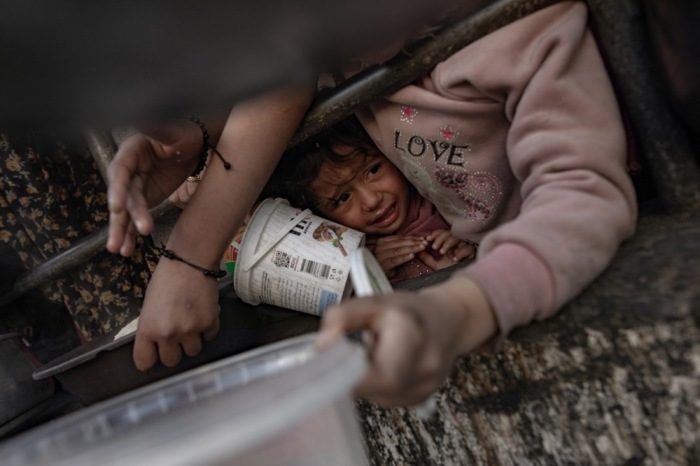 Das Kind reagiert, als vertriebene Palästinenser vor dem Frühstück die von einer Wohltätigkeitsorganisation gespendeten Lebensmittel einsammeln. Foto epa/HAITHAM IMAD