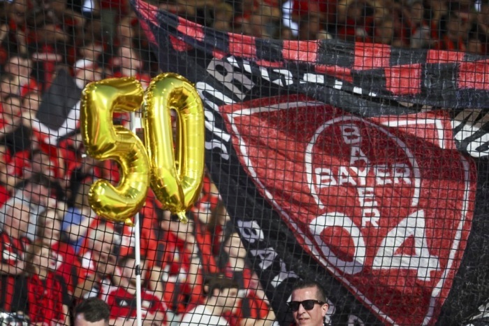 Die Fans von Leverkusen feiern die Mannschaft, die in dieser Saison in allen Wettbewerben 50 Spiele ungeschlagen geblieben ist, nach der Bundesliga. Foto: epa/Christopher Neundorf