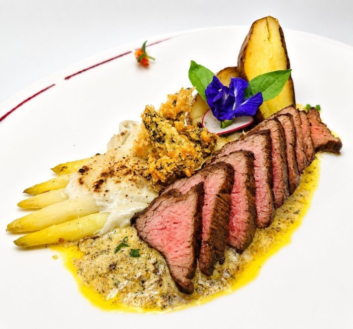 Australisches Rinderfilet mit Kräuterbutter, Steinpilzen, weißem Spargel und Ofenkartoffel. Fotos: Vespresso Restaurant