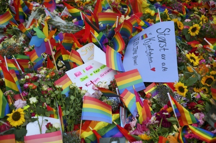 Blumen und Regenbogenfahnen liegen nahe dem Tatort nach der Schießerei vor dem London Pub im Zentrum von Oslo. Foto: epa/Martin Solhaug Standal