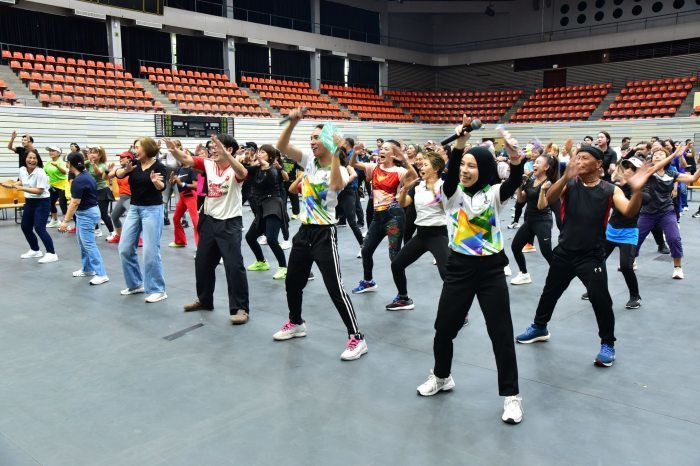 Teilnehmer eines Fitnessprogramms absolvieren gemeinsame Bewegungsübungen in einer Sporthalle in Thailand. Mehr körperliche Aktivität gilt als wichtiger Ansatz zur Vorbeugung chronischer Krankheiten. Bild: Bangkok Metropolitan Administration (BMA)