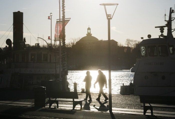 Die Menschen schlendern bei kaltem, aber sonnigem Wetter am Standvagen-Kai in Stockholm entlang. Foto: epa/Fredrik Sandberg