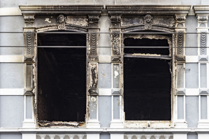 Zwei Fenster mit Brandspuren am Brandort in Solingen nach dem Pressestatement der Staatsanwaltschaft Wuppertal zum tödlichen Brand in Solingen. Foto: Christoph Reichwein/dpa