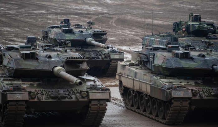 Drei Kampfpanzer der Bundeswehr vom Typ Leopard 2A6 und ein Schützenpanzer vom Typ Puma stehen bei einer Übung im Gelände. Foto: Philipp Schulze/dpa