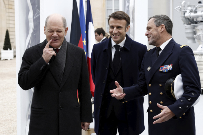 Bundeskanzler Olaf Scholz (SPD, l) und Emmanuel Macron (M), Präsident von Frankreich, lächeln, während der Präsentation deutsch-französischer Industrieprojekte im Rahmen des Deutsch-Französischer Ministerrats ... Foto: Benoit Tessier/Reuters Pool