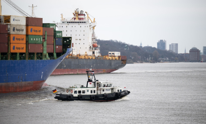Ein Lotsenboot fährt neben einem Containerschiff in den Hamburger Hafen. Foto: Daniel Reinhardt/dpa