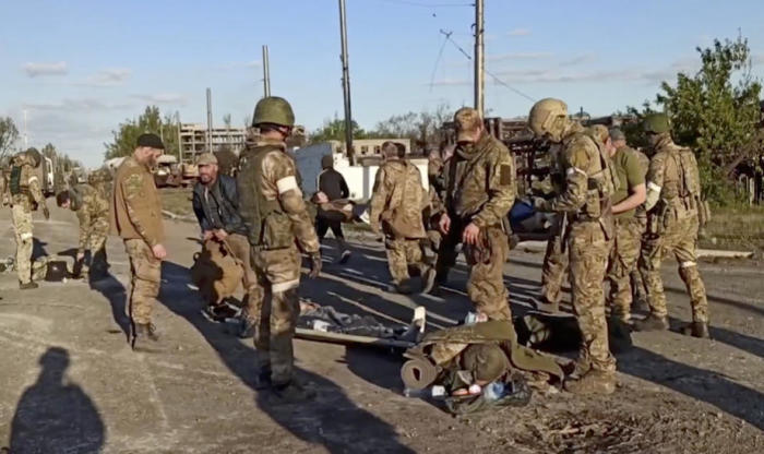 Russische Soldaten filzen ukrainische Soldaten, als sie aus dem belagerten Stahlwerk Azovstal in Mariupol evakuiert werden. Foto: epa/Presse Des Russischen Verteidigungsministeriums S