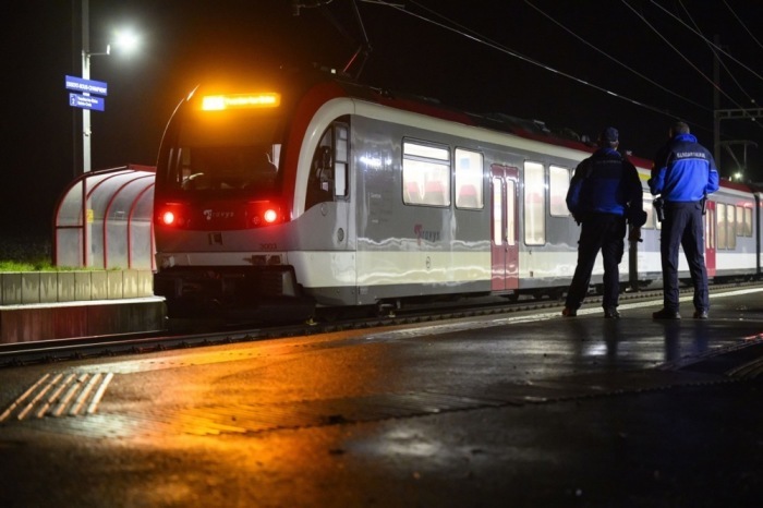 Zwei Waadtländer Kantonspolizisten schauen sich den Travys-Zug an, in dem eine Geiselnahme stattgefunden hat. Foto: epa/Laurent Gillieron