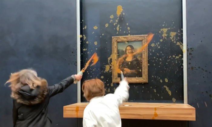 Zwei Umweltaktivisten des Kollektivs «Riposte Alimentaire» (Vergeltung für Lebensmittel) bewerfen im Pariser Louvre das Gemälde «Mona Lisa» von Leonardo da Vinci mit Suppe (Videostandbild). Foto: David Cantiniaux/Afptv/afp/dpa