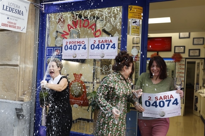 Angestellte einer Lottoannahmestelle zeigen Banner mit der Gewinnzahl des zweiten Preises der traditionellen Weihnachtslotterie, bekannt als 