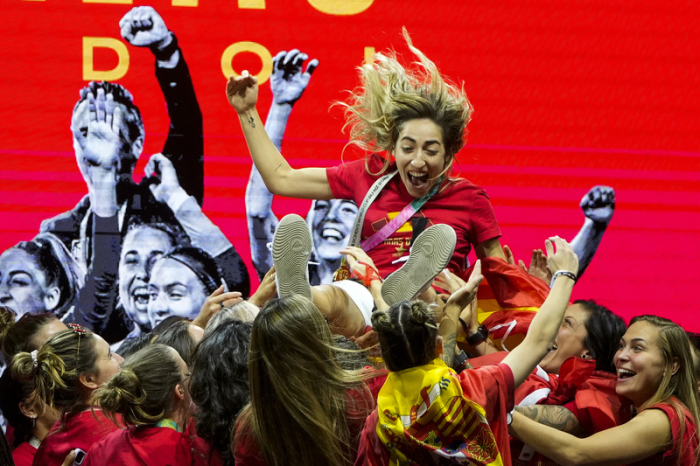 Spielerinnen der spanischen Frauenfußballnationalmannschaft heben die spanische Nationalspielerin Olga Carmona hoch, während sie auf der Bühne ihren Sieg bei der Fußballweltmeisterschaft feiern. Foto: Manu Fernandez/Ap/dpa