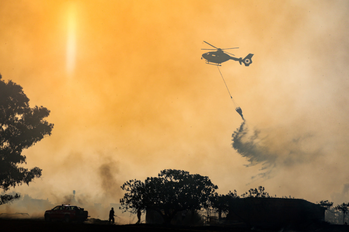 Feuerwehrleute bekämpfen mit einem Hubschrauber einen Waldbrand im Naturschutzgebiet Acquafredda bei Rom. Foto: Francesco Benvenuti/Lapresse/ap/dpa