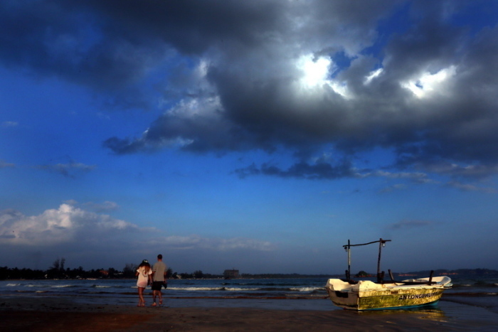 Touristen gehen am Strand von Mirissa, Sri Lanka, entlang. Foto: M.A.Pushpa Kumara/dpa