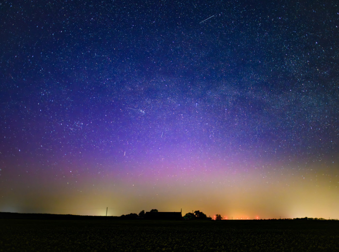 Ein Polarlicht leuchtet über Ostbrandenburg am Nachthimmel und färbt den Himmel in violette Töne. Foto: Patrick Pleul/dpa