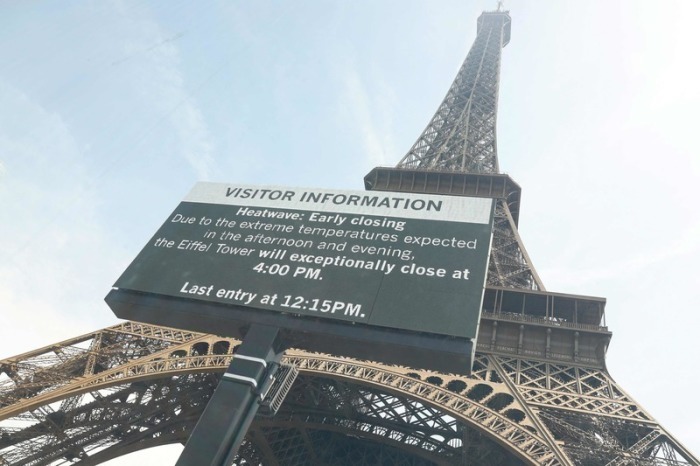 Der Eiffelturm in Paris mit einer Hinweistafel zur vorzeitigen Schließung wegen der anhaltenden Hitzewelle in Frankreich. Foto: AFP/dpa/charlotte Siemon