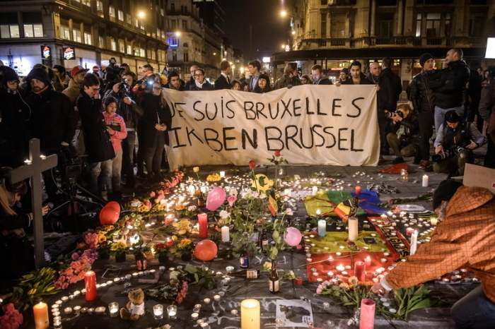 Menschen trauern und stehen neben Kerzen und Blumen am Abend des Tages der islamistischen Terror-Anschläge. Foto: Christophe Petit Tesson