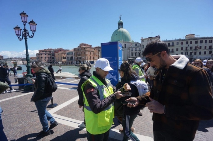 Ein Kontrolleur prüft die Eintrittskarten für den Eintritt in die Stadt Venedig. Foto: epa/Andrea Merola