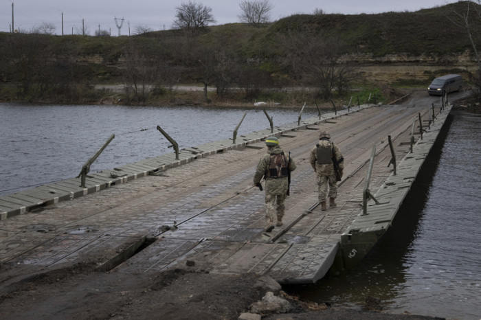 Ukrainische Soldaten gehen auf einer Pontonbrücke über den Fluss Inhulez in der Region Cherson. Foto: Evgeniy Maloletka/Ap/dpa