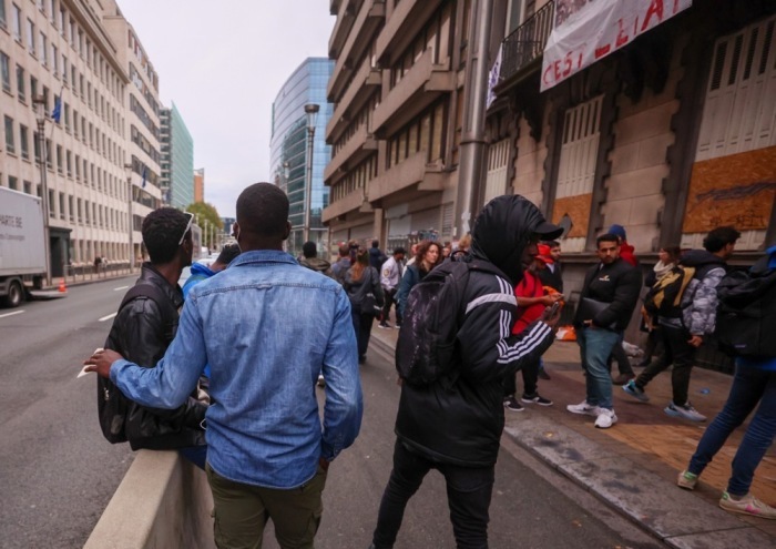 In Brüssel versammeln sich Asylbewerber auf der Straße, als sie ein besetztes Gebäude in der Rue de la Loi verlassen. Foto: epa/Olivier Hoslet