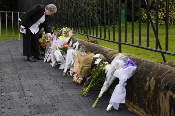 Eine Frau betrachtet Blumen die vor dem Gouvernement House nach dem Tod von Königin Elizabeth II. niedergelegt wurden. Die britische Königin Elizabeth II. ist tot. Foto: Mark Baker